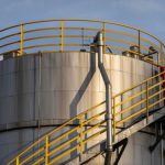 Industrial steel storage tank with safety railings and stair access.