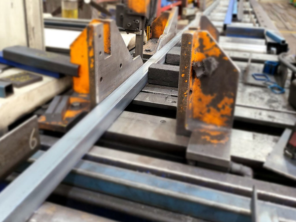 Close-up of bandsaw being processed with precision machinery.