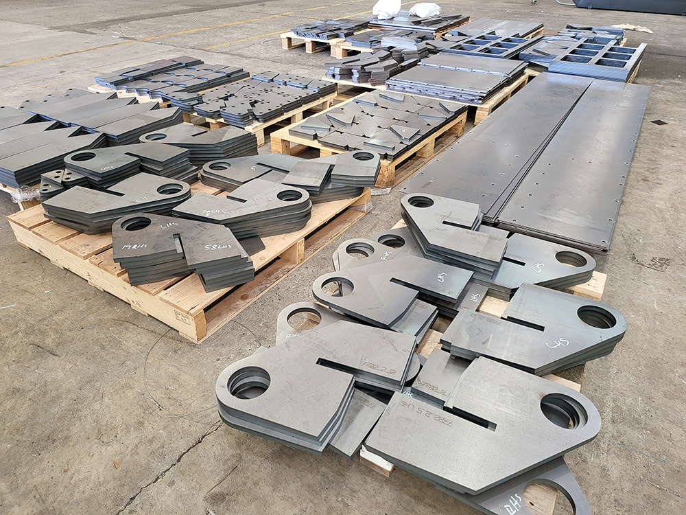 Stacked laser-cut steel parts on pallets